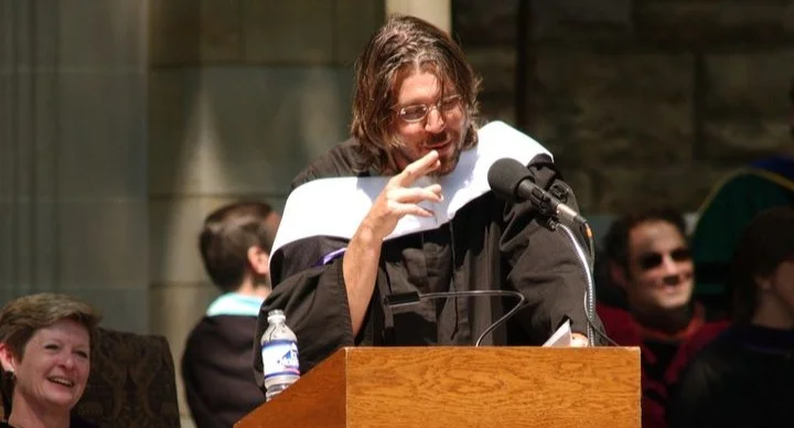 a woman standing at a podium in front of a crowd