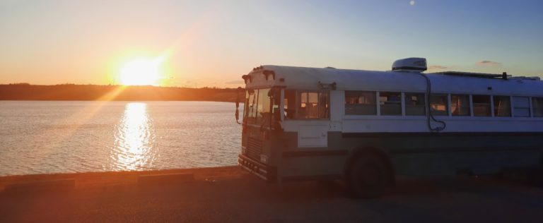 a bus parked on the side of a road near water