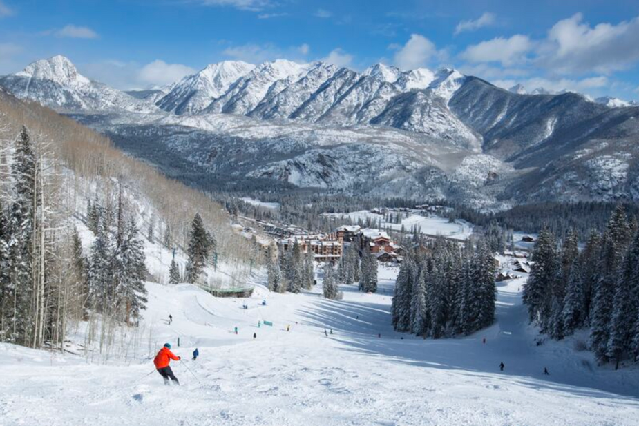 skiers are skiing down a snowy mountain slope