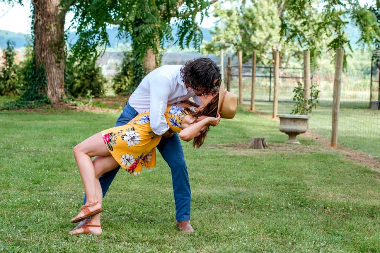 a man and woman are kissing in the grass