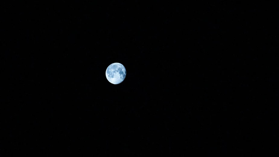the full moon is seen in the dark sky