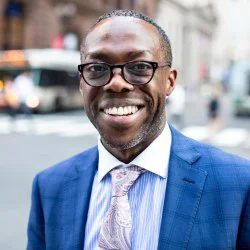 a man in a suit and tie standing on the street