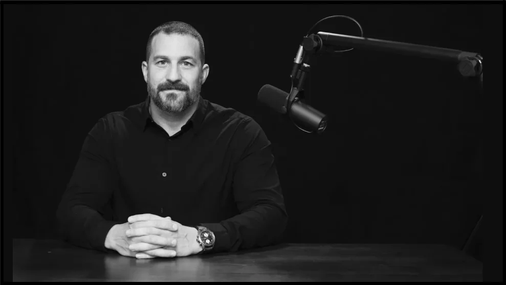 a man sitting at a table in front of a microphone