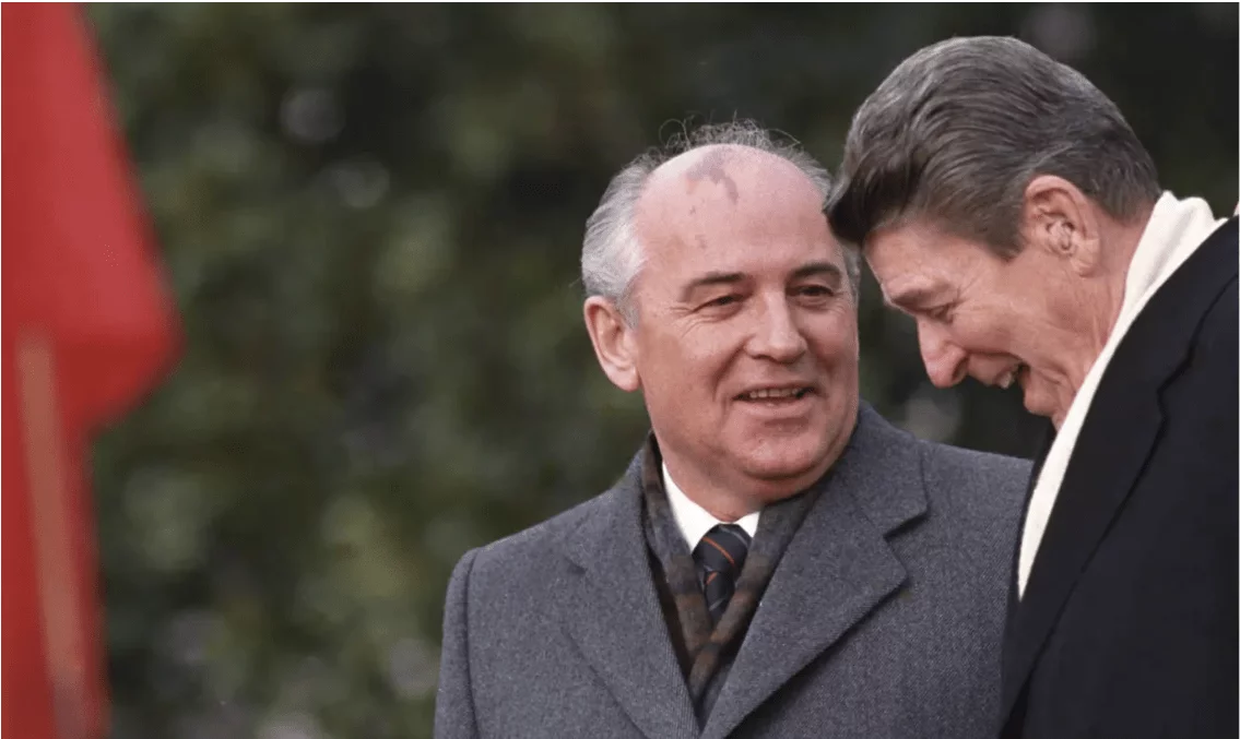 two men in suits and ties standing next to each other